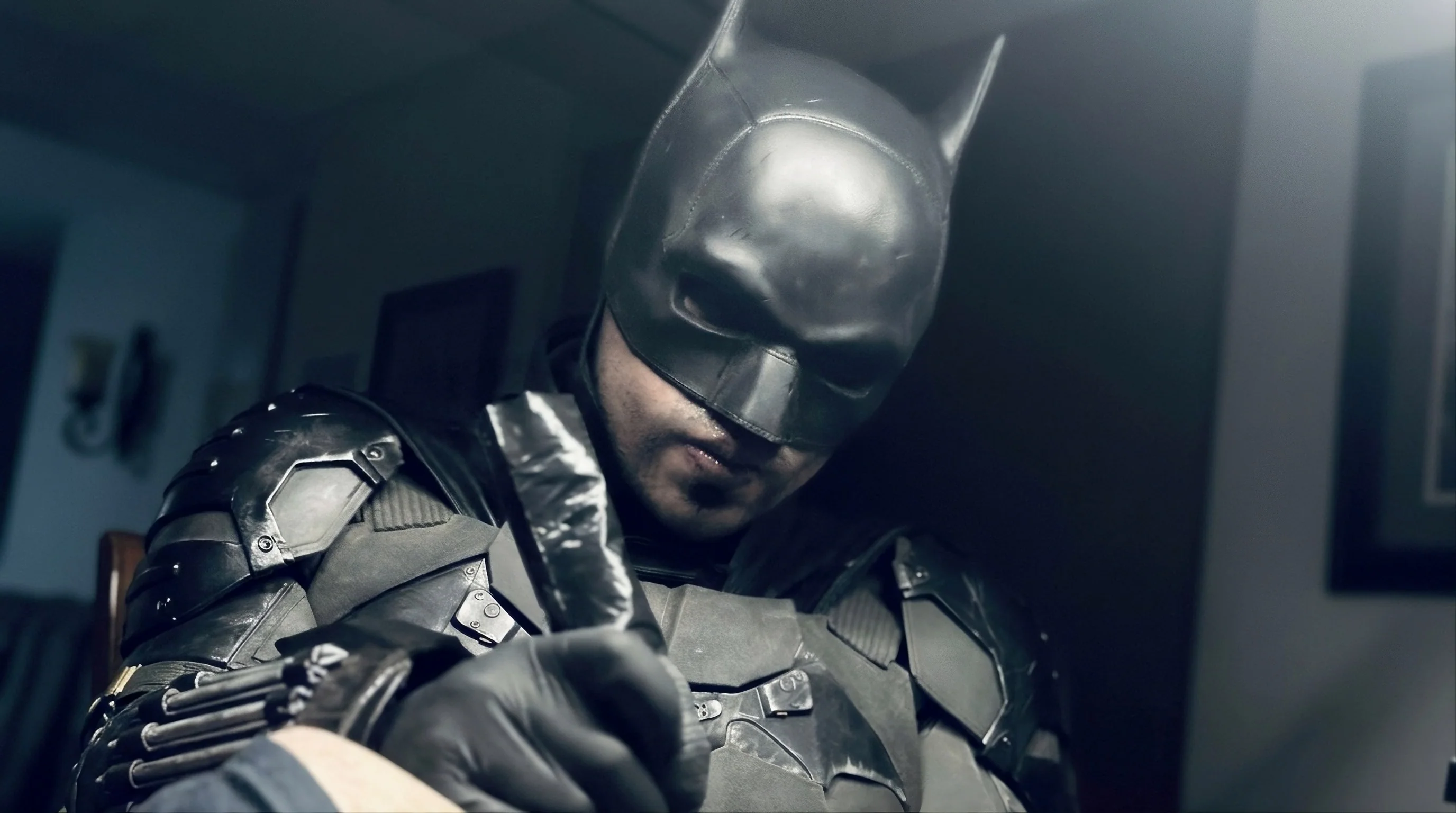 Edd Arrows in his black suit and mask, tattooing at the studio